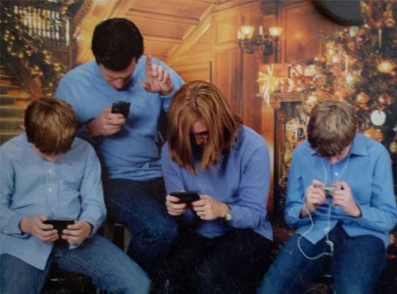 Family looking down at cellphones