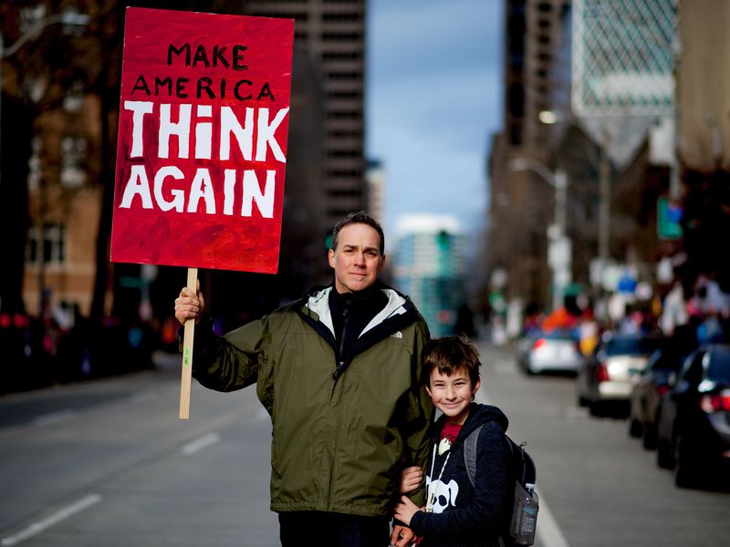 Father and son holding sign in Seattle