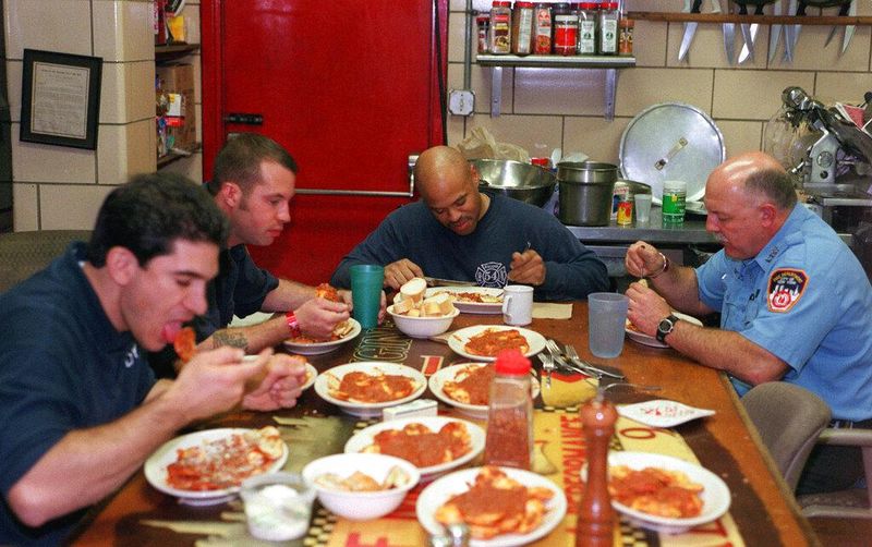 Firefighters eat dinner at New York's Broadway firehouse in 2001