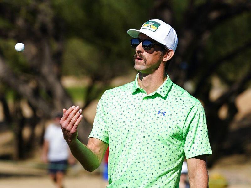 Former U.S. Olympic gold medal swimmer Michael Phelps tosses his golf ball