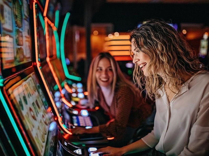 Friends gambling on slot machines in casino