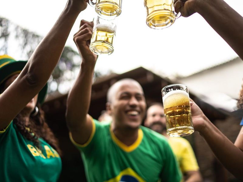 Friends toasting to celebrate Brazilian soccer team winning
