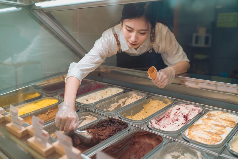 Gelato cafe worker scooping for a customer order