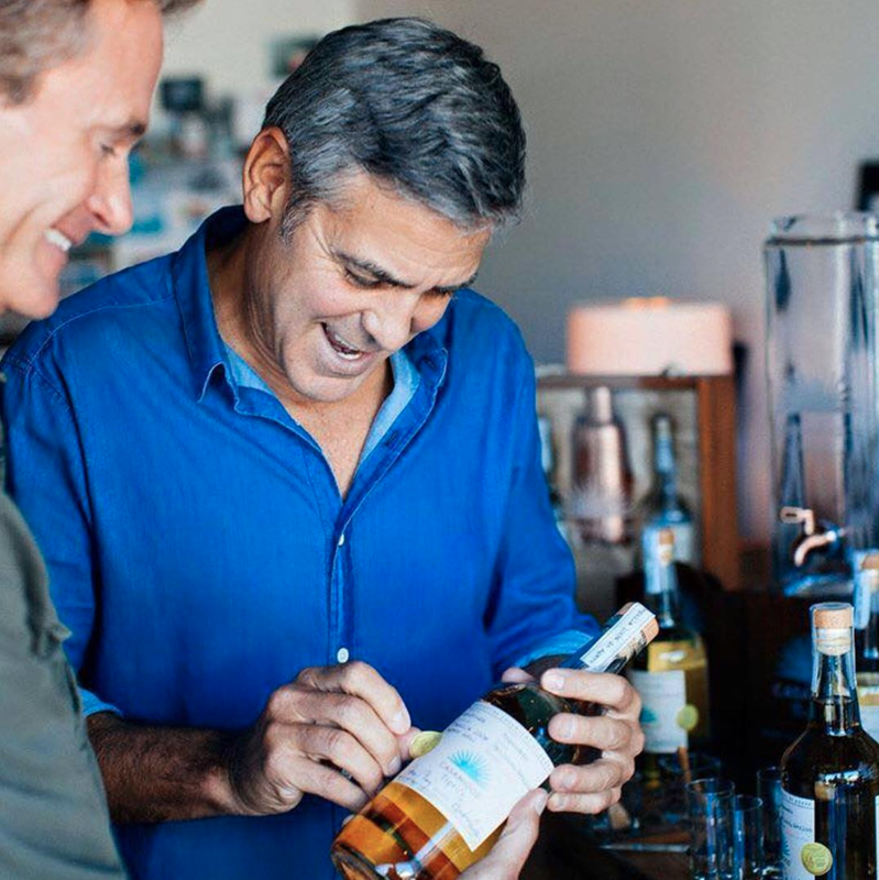 George Clooney signs a bottle of Casamigos tequila.