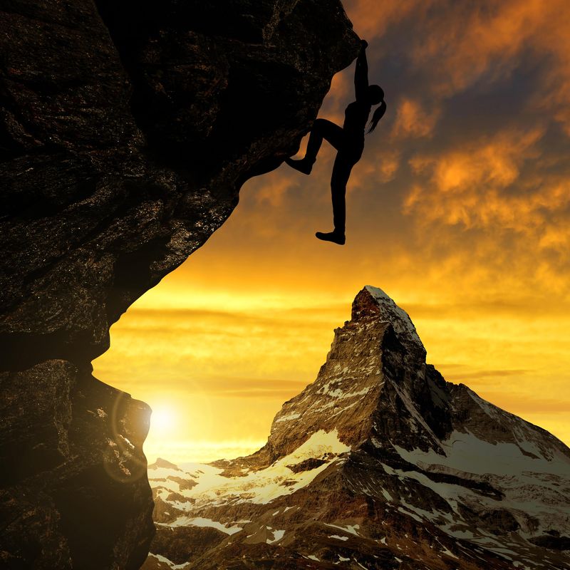 Girl climbing on rock at sunset next to Matterhorn in Switzerland