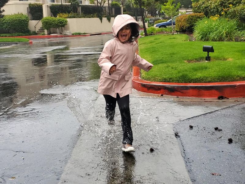 Girl having fun running the rain