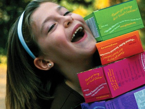 Girl Scout with cookie boxes
