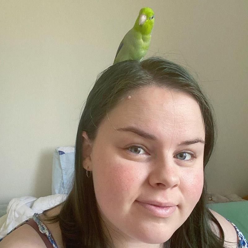 Girl with pet green parrot
