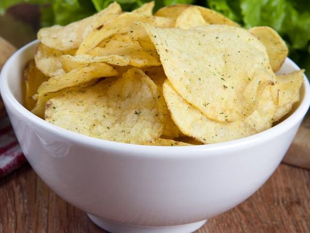 glass bowl with potato chips and vegetables