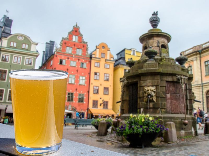 Glass of light beer against view of Stockholm city center on Gamla stan, Sweden