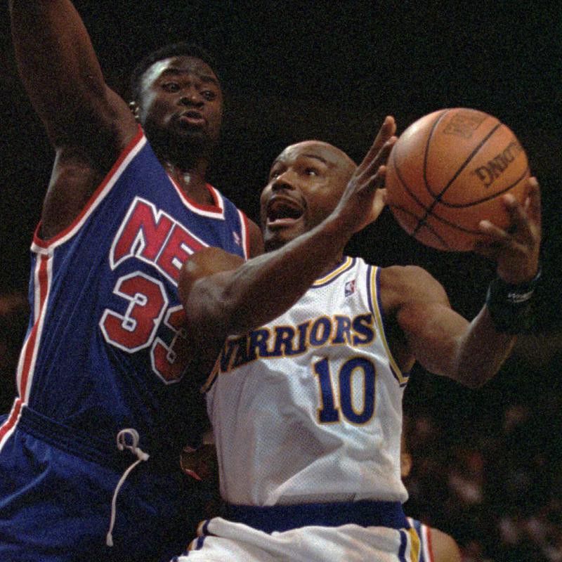 Golden State Warriors' Tim Hardaway goes up for basket as New Jersey Nets' Yinka Dare guards