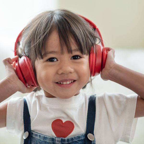 Portrait of happy Asian child enjoy listening to music with headphones