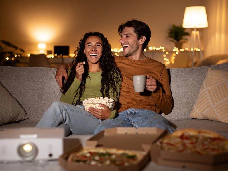 Happy couple enjoying home cinema night