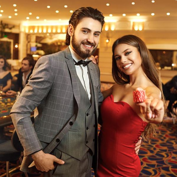 Happy couple holding roulette chips in their hands. A couple of gambling games. Concept Casino.