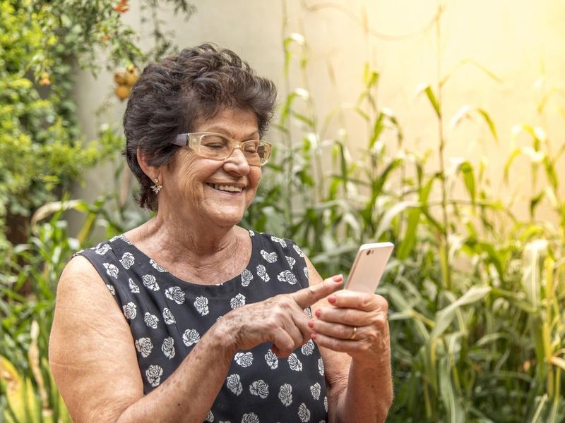 happy elderly woman using cellphone