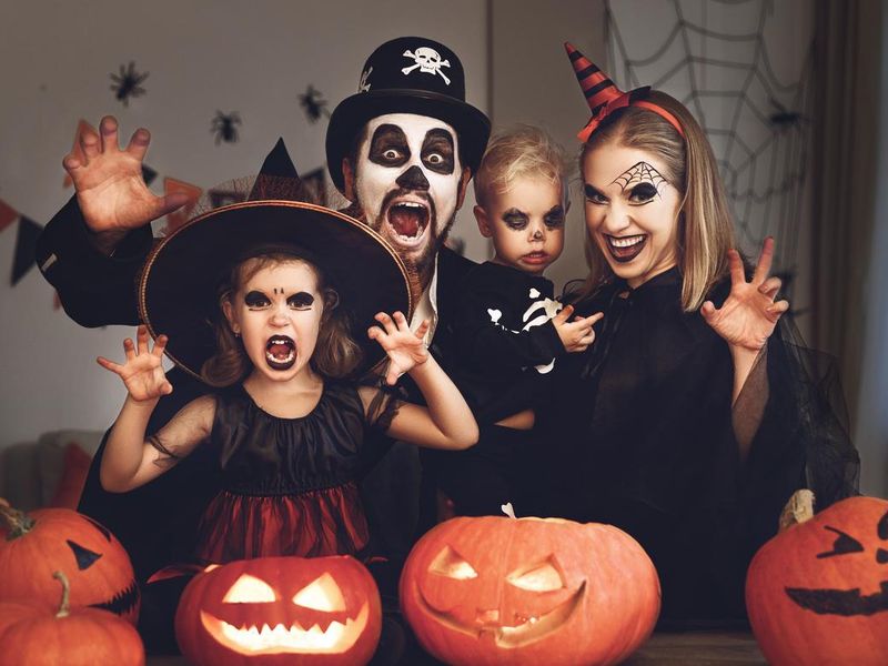 Happy family mother father and children in costumes and makeup on  Halloween