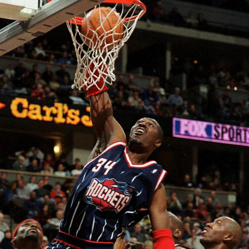 Houston Rockets center Hakeem Olajuwon dunks ball over Denver Nuggets center Popeye Jones