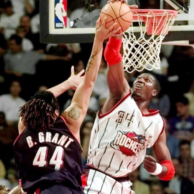 Houston Rockets' Hakeem Olajuwon goes up to block shot of Portland Trail Blazers' Brian Grant