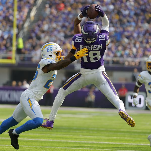 Minnesota Vikings wide receiver Justin Jefferson (18) catches a pass over Los Angeles Chargers cornerback Asante Samuel Jr. (26) during the first half of an NFL football game, Sunday, Sept. 24, 2023, in Minneapolis. (AP Photo/Bruce Kluckhohn)