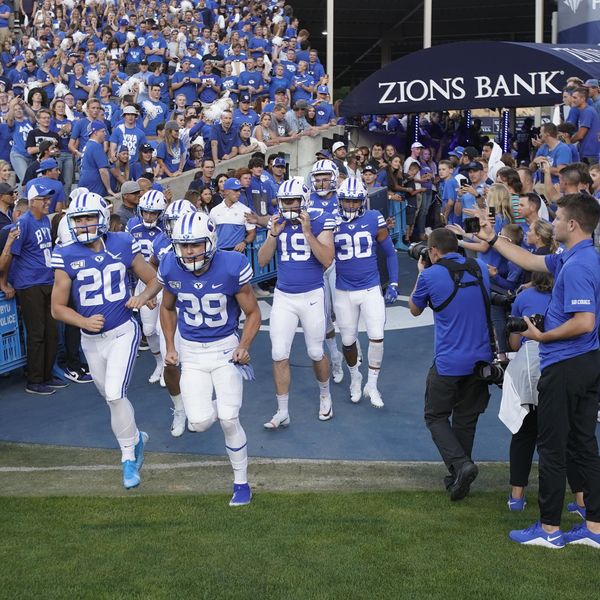 FILE - BYU football players enter the field to warm up for an NCAA college football game against Utah in Provo, Utah, Thursday, Aug. 29, 2019. NCAA enforcement has inquired about how college athletes are earning money off their names, images and likenesses at multiple schools as it attempts to police activities that are ungoverned by detailed and uniform rules. BYU is the one school that has publicly acknowledged providing the NCAA with information about an NIL deal. (AP Photo/George Frey, File)