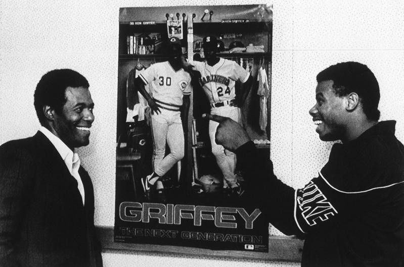 Ken Griffey Sr. and Ken Griffey Jr. joke around by poster in Cincinnati