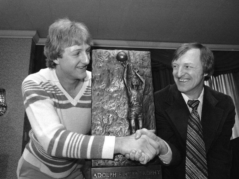 Larry Bird and coach holding trophy
