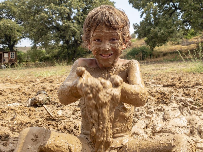 Little boy playing in mud
