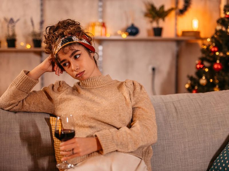 Lonely woman drinking wine during Christmas holiday