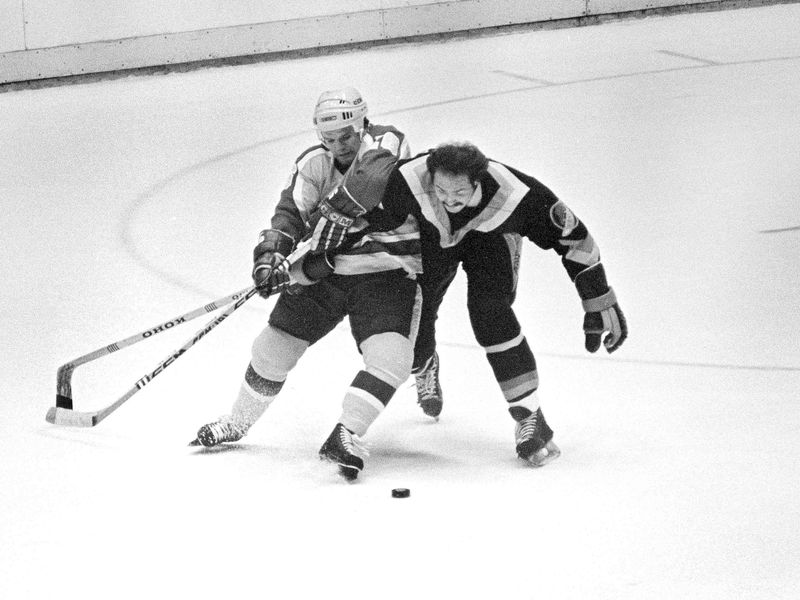 Los Angeles Kings Marcel Dionne and Vancouver Canucks Harold Snepsts battle for puck