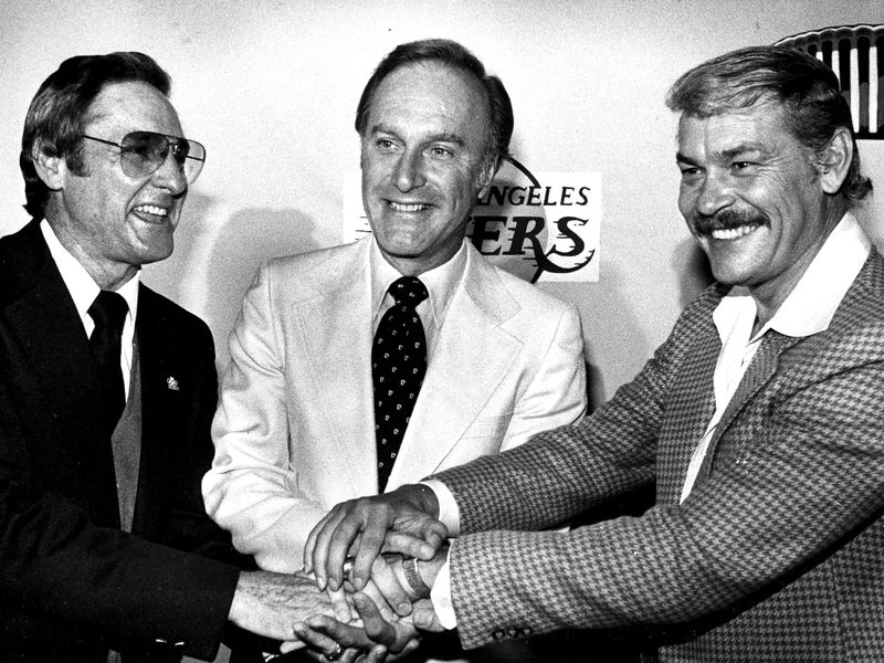 Los Angeles Lakers general manager Bill Sharman, left, and owner Jerry Buss, right, congratulate Jack McKinney