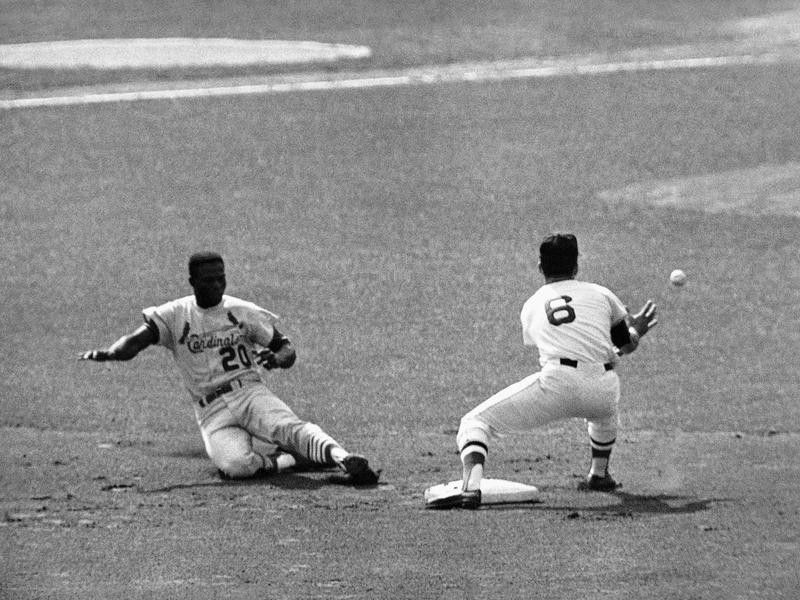 Lou Brock slides head first into third base