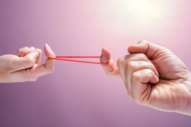 Man and woman stretching rubber band