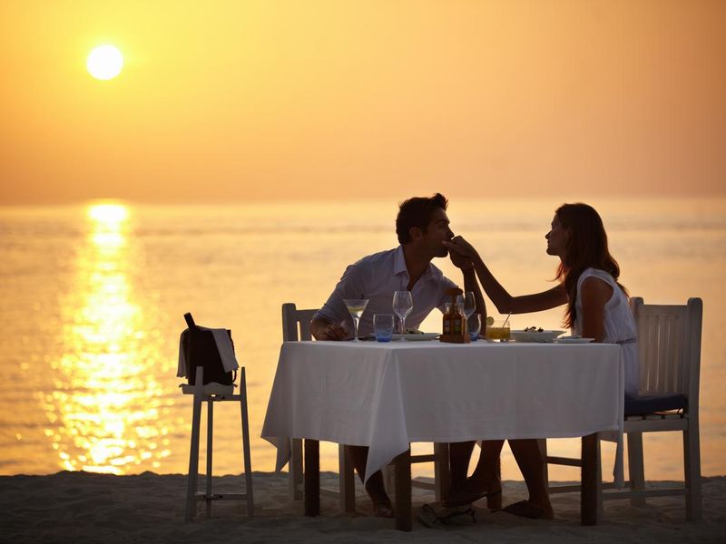 Man having dinner on the beach with his girlfriend
