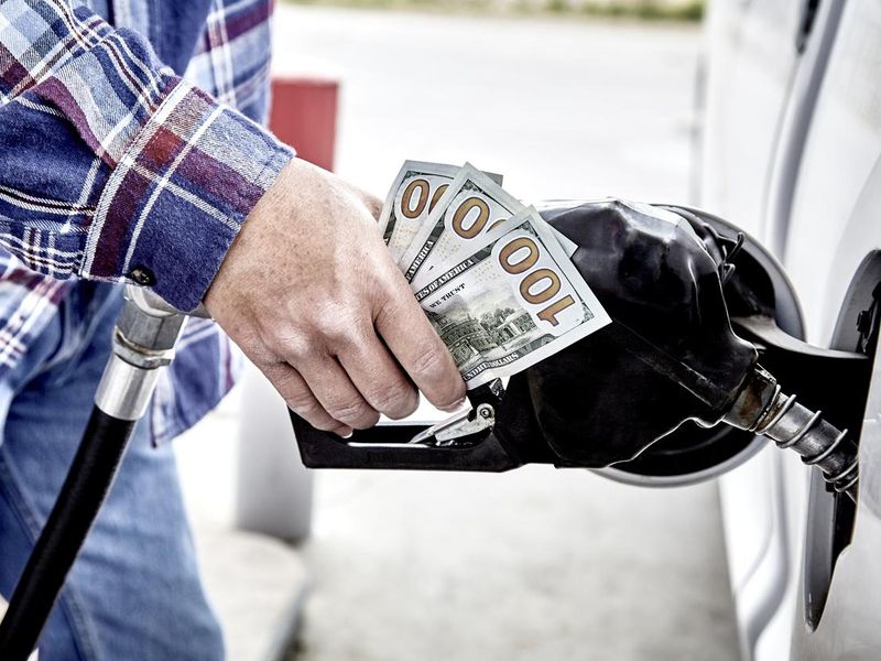 Man holding cash because gas prices are so high