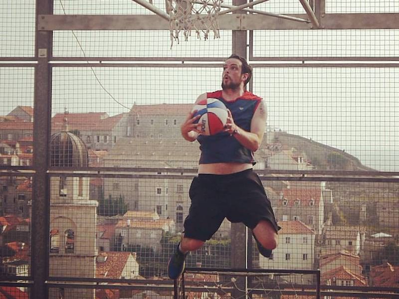 Man playing basketball at City Wall Rooftop Court