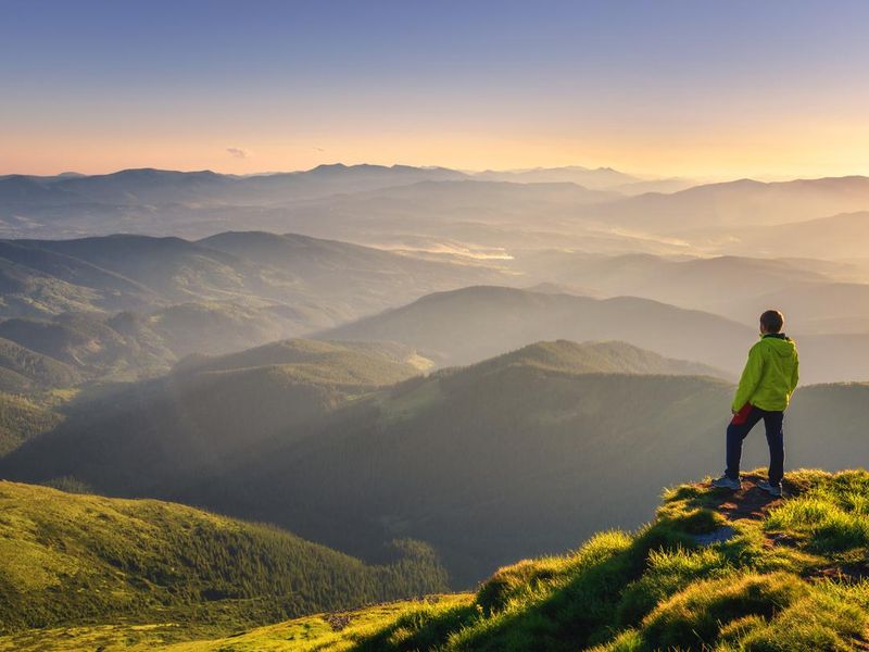 Man watching sunrise on a mountain peak