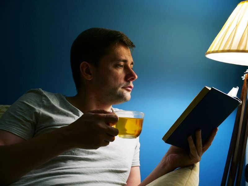 Man with cup of tea and book