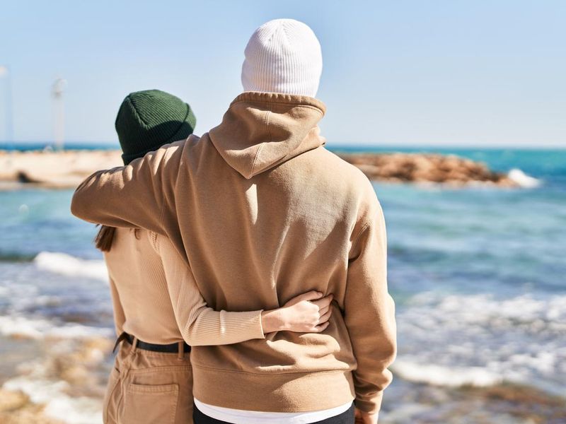 Mand and woman couple hugging each other at seaside