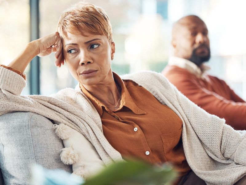 Mature couple, divorce and fighting on sofa in house, home living room or marriage counseling therapy. Stress, frustrated or depression for black woman and man in psychology counselling for cheating
