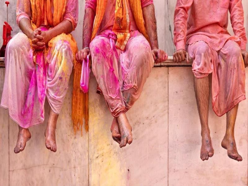 Men sitting on wall during Holi