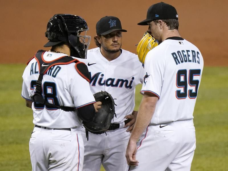 Miami Marlins starting pitcher Trevor Rogers talks with catcher Jorge Alfaro