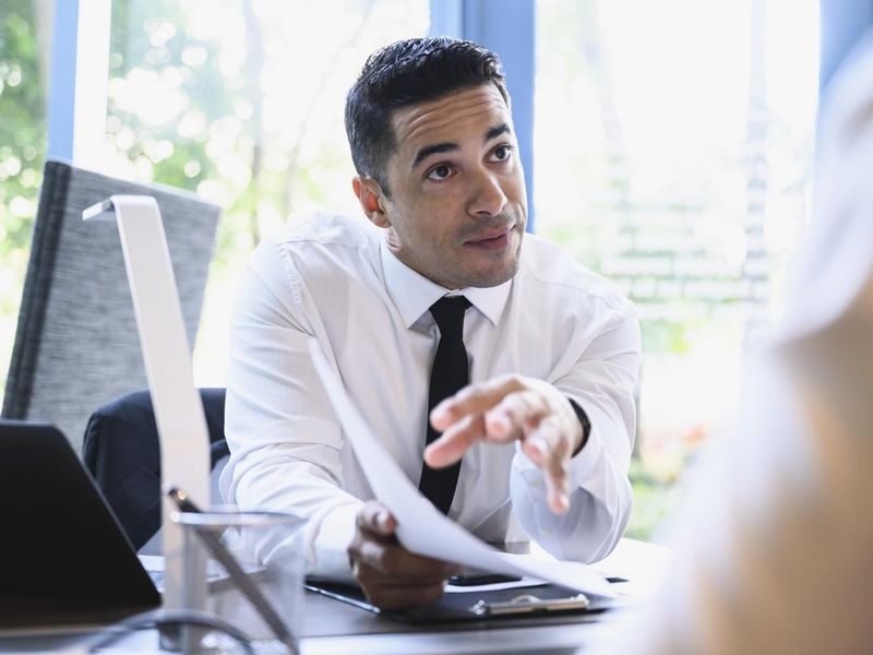Mid 30s businessman explaining merits of plan to colleague