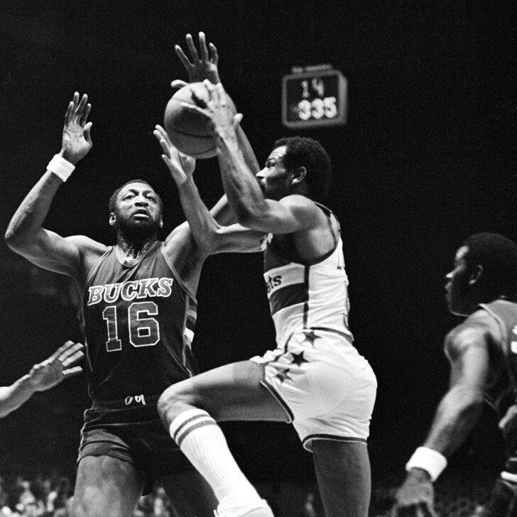Milwaukee Bucks Bob Lanier, puts his hand over the top of the ball to block a two point attempt by Washington Bullets John Lucas