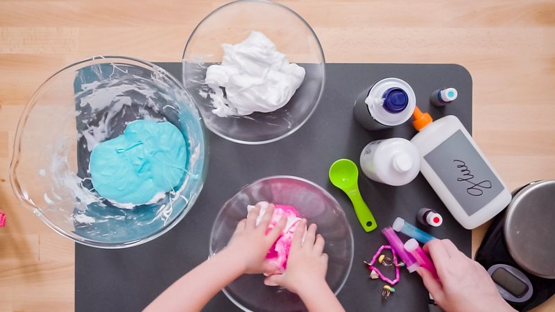 Mother and daughter making colorful fluffy slime