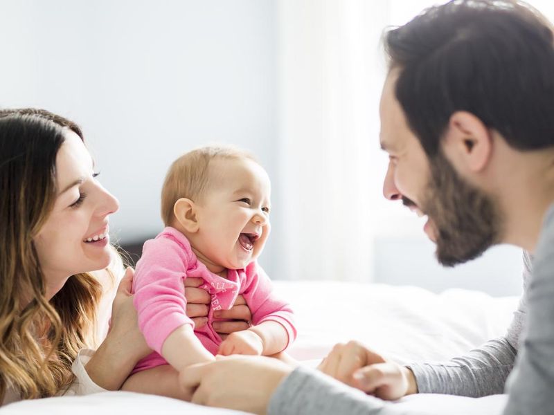 Mother and father laughing with baby