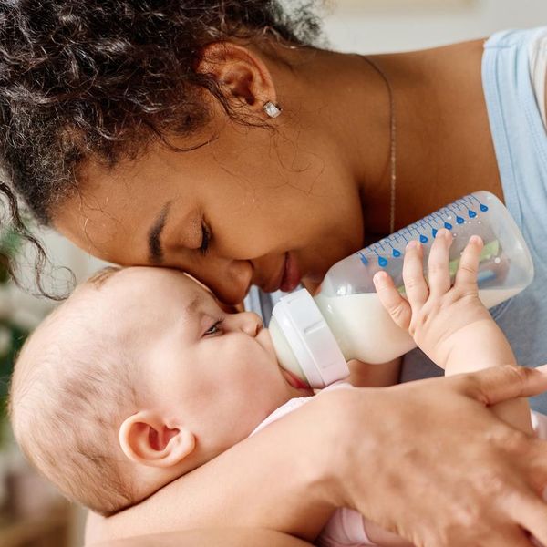 Happy mother enjoying her time with baby while he eating milk from bottle
