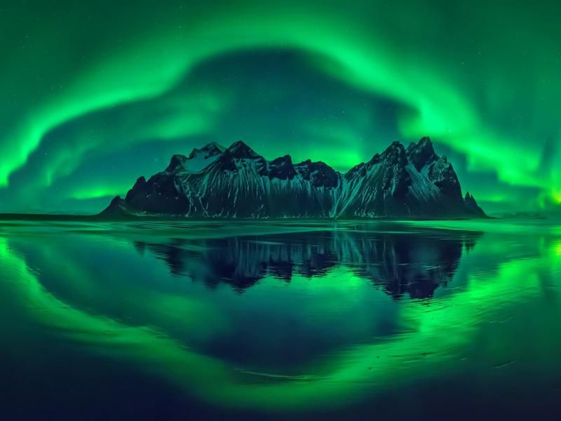 Natural Wonder: Northern lights over a mountain
