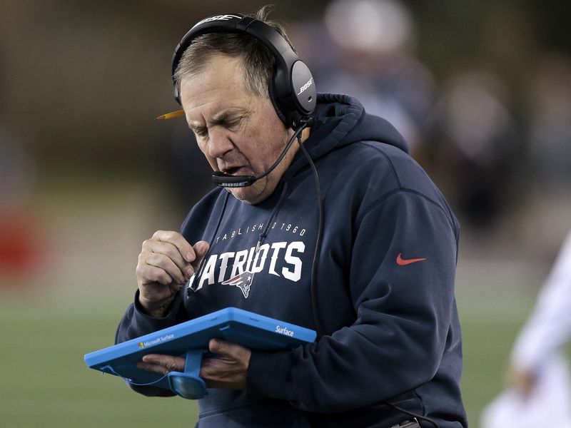 New England Patriots head coach Bill Belichick studies a tablet device