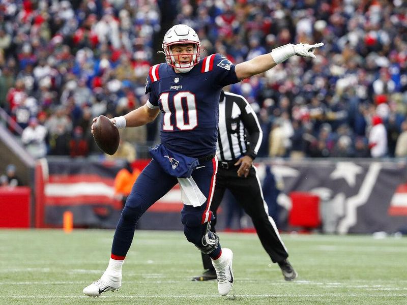 New England Patriots quarterback Mac Jones points on the field