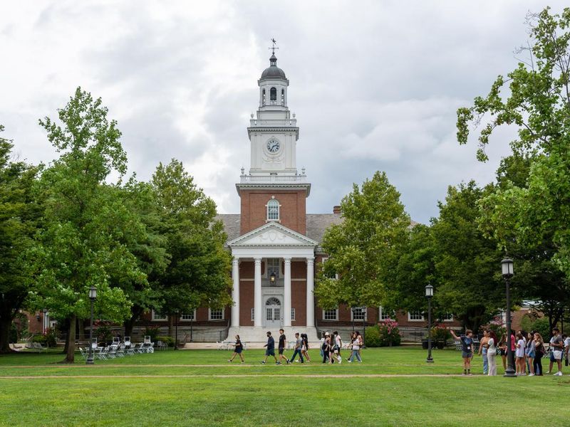 New students walk past Gilman Hall on the Johns Hopkins University campus